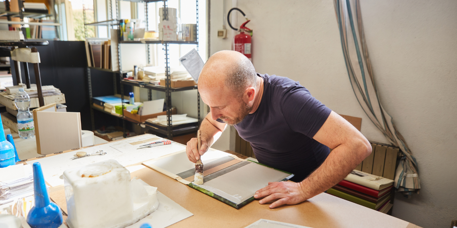 Man working on book binding - What Happens During an Adhesive Audit? What to Know