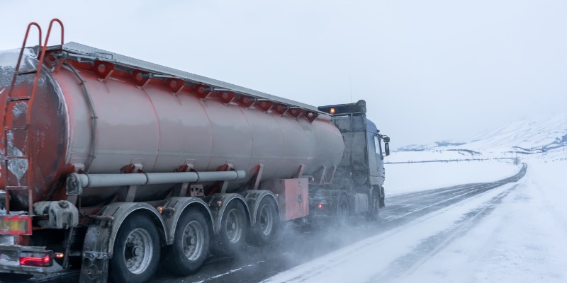 Fuel tanker truck driving in extreme winter conditions on highway